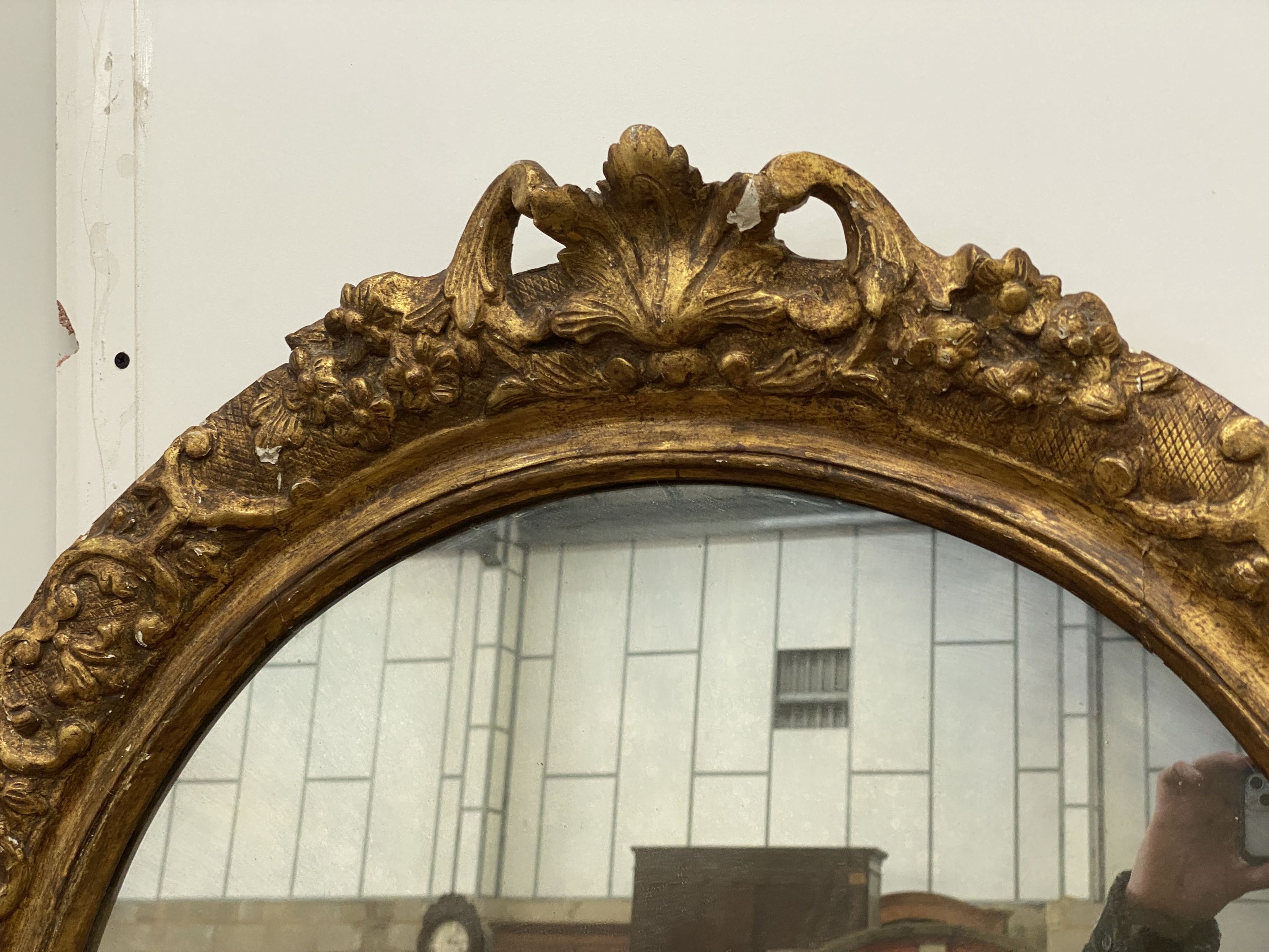 An oval giltwood and gesso wall mirror, width 89cm, height 108cm